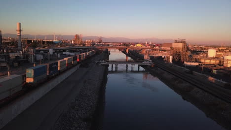 Los-Angeles-river-crossing-industrial-square-zone-railyard-aerial-at-sunset