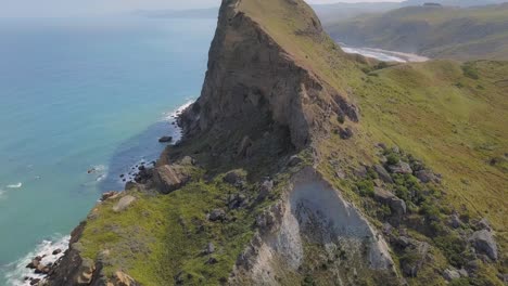 Aerial-reveal-of-Castle-Rock-on-the-east-coast-of-Wairarapa,-New-Zealand