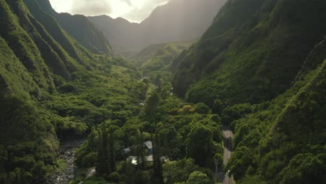 4k-aerial-drone-shot-panning-up-over-lush-green-valley-with-sun-rays-in-Hawaii