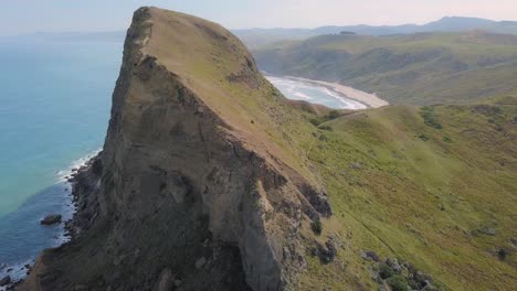 Aerial-view-of-Castle-Rock-with-hiking-trails-at-Castlepoint,-New-Zealand,-dolly-out