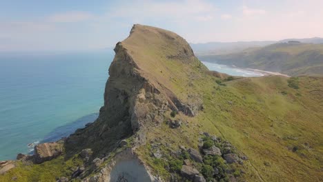Aerial-view-rising-over-Castle-Rock-on-the-shoreline-of-Castlepoint,-New-Zealand
