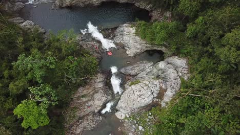 Birds-Eye-Aerial-View-of-Secluded-Charco-El-Ataud-Waterfall-and-Rainforest,-Puerto-Rico,-Adjustas