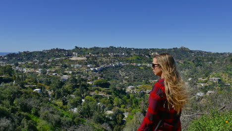Young-girl-with-flowing-long-brown-hair,-looks-out-over-a-valley-in-Los-Angeles-California