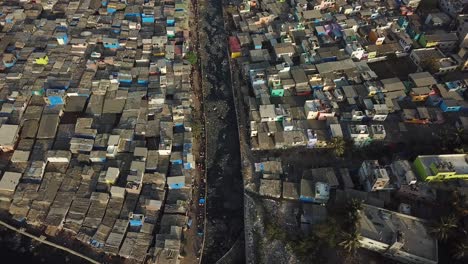Vista-Aérea-Cinematográfica-Sobre-El-Canal-Del-Río-Sucio-Y-El-Barrio-Pobre-De-Dharavi-En-Mumbai,-India