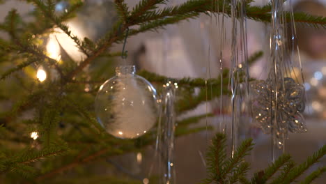 Hanging-transparent-Christmas-Baubles-in-real-Christmas-tree,-Close-up