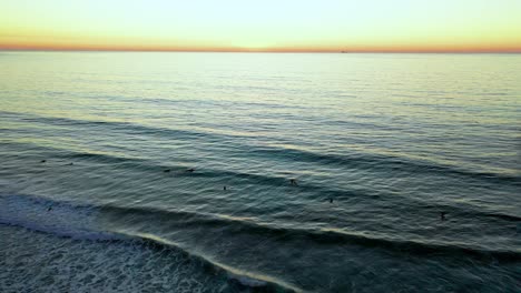 Luftaufnahme-Von-Scripps-Pier-Bei-Sonnenuntergang-über-Dem-Ozean-Mit-Surfern-In-San-Diego,-Kalifornien