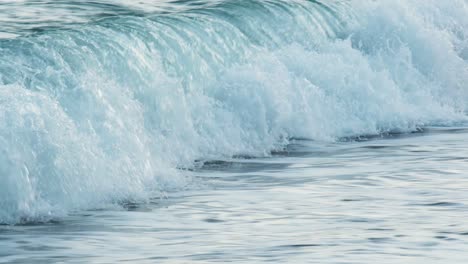 Slow-motion-of-beautiful-blue-sea-water-waves-splashing-against-tropical-sand-beach