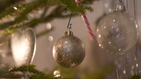 Real-fresh-cut-Christmas-tree-decorated-with-glitter-ornaments-and-glass-baubles,-close-sliding-dolly-shot