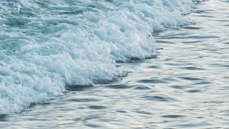 Pan-shot-of-powerful-sea-water-waves-splashing-against-tropical-sand-beach