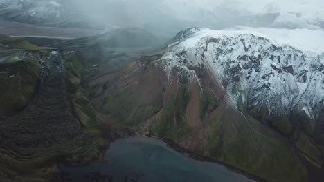Highlands-of-Iceland,-Aerial-View-of-Breathtaking-Landscape,-Snow-on-Volcanic-Mountain-Peak,-Glacial-Lake-in-Valley