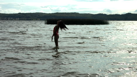 Silhouette-of-woman-throwing-own-hairs-into-air-in-ocean,slow-motion-shot
