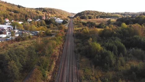Aerial-Bird's-Eye-View-of-Train-passing-on-railway-tracks-in-Gothenburg,-Sweden-during-the-day