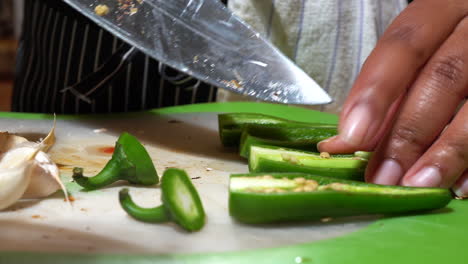 Hands-of-Black-Woman-Slicing-Out-Center-of-Jalapeno-Peppers,-Extreme-Close-Up