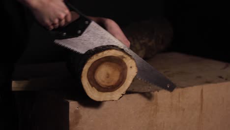Rigorously-cutting-a-wooden-log-at-workshop,-closeup