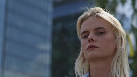 Blonde-adult-woman-looking-first-angry-and-then-happy-in-camera,during-shooting-in-city