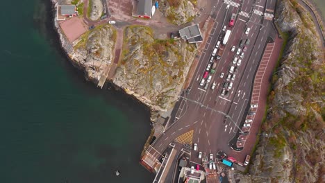 Top-down-aerial-drone-view-of-docked-car-ferry-with-vehicles-disembarking-in-Gothenburg's-northern-archipelago,-Sweden