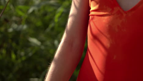 Static-shot-of-female-person-in-red-summer-dress,relaxing-outdoor-in-nature,slowmo
