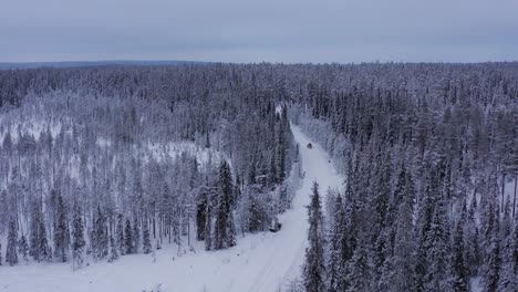 Autos-Mit-Dachbox,-Die-Während-Der-Wintersonnenwende-Auf-Einer-Schneebedeckten-Querfeldeinstraße-Durch-Lappland-Fahren
