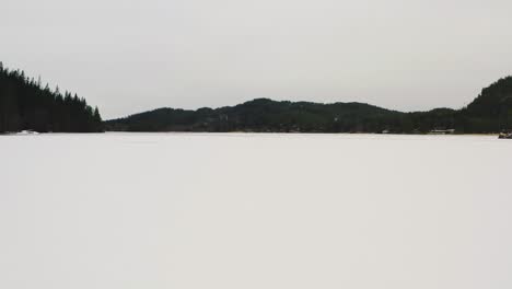 Snowy-landscape-of-a-frozen-lake-covered-in-snow-in-winter-in-the-northern-Norway