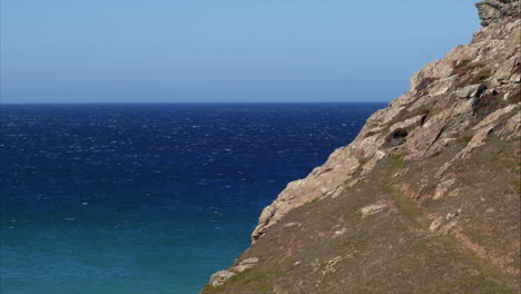 Looking-at-the-beautiful-blue-sea-and-sky-of-Cornwall,-England-on-a-bright-sunny-day---Wide-pan-shot