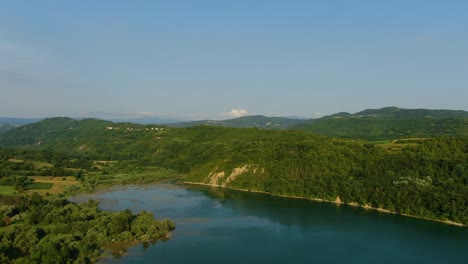 Lake-Butoniga-water-dam-in-Croatia-shore-approach,-Aerial-drone-left-pan-reveal-shot