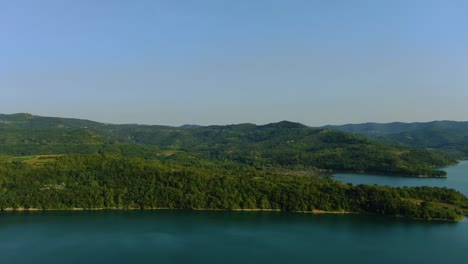 Lake-Butoniga-water-dam-in-Croatia-surrounded-by-mountains,-Aerial-drone-left-pan-reveal-shot