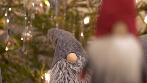 Süßer-Weihnachtsschmuck-Schneller-Rackfokus,-Zwei-Weihnachtsmannpuppen,-Weihnachtsbaumhintergrund
