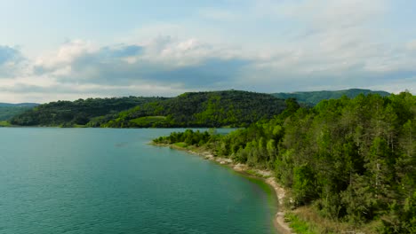 4k-aerial-drone-shot-over-shoreline-and-island-outcropping-of-a-lake-in-Europe