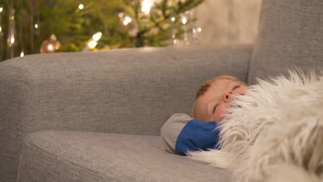Exhausted-toddler-boy-in-sofa,-waking-up-after-Christmas-celebrations,-dreamy-shallow-depth-of-field