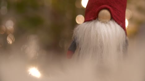 Dreamy-Santa-Claus-toy,-Christmas-holiday-decoration-with-bokeh-christmas-tree-in-the-background,-slider-shallow-depth-of-field