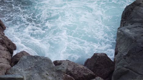 Blaues-Ozeanwasser,-Das-Gegen-Felsen-Stürzt