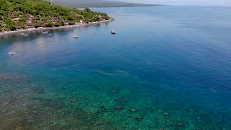 Aerial-reveal-shot-over-the-blue-lagoon-Amed-in-Bali,-Indonesia