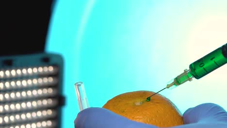Injecting-orange-science-test-pesticide-GMO-testing-hypodermic-needle-isolated