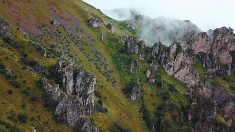 Aerial,-drone-shot,-towards-rocky-nature-and-fog,-in-the-Andes-mountains,-on-a-cloudy-day,-near-Cuzco,-in-Peru