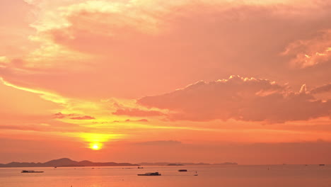 Gesperrte-Weite-Aufnahme-Eines-Wunderschönen-Orangefarbenen-Goldenen-Sonnenuntergangs-über-Dem-Ozean-In-Thailand-Mit-Kleinen-Fischerbooten-Und-Bergen-Am-Horizont