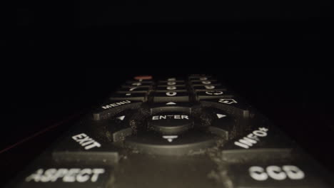 Extreme-close-up-dolly-of-a-dirty-television-remote---dust-and-dirt-visible-between-the-buttons