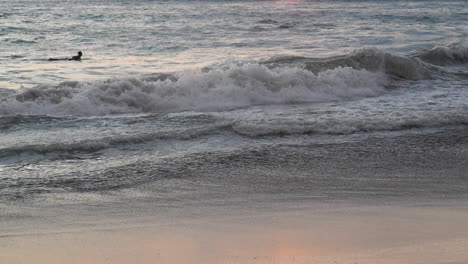Neigung-Enthüllen-Surfer,-Die-Im-Ozean-Paddeln,-Und-Einen-Malerischen-Sonnenuntergang-Im-Hintergrund