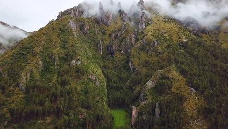 Aerial,-rising,-drone-shot-of-rocky,-green-mountains,-covered-in-fog,-in-the-Andes,-on-a-overcast-day,-near-Cuzco,-in-Peru