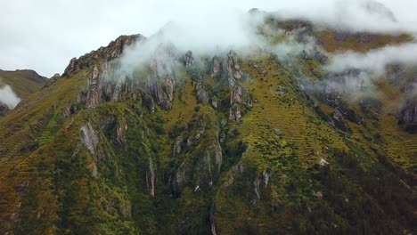 Aerial,-drone-shot-of-low-clouds-on-rocky-Andes-mountains,-on-a-cloudy-day,-near-Cusco,-in-Peru,-South-America