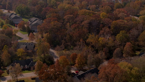 Aerial-view-of-suburbs-in-the-Fall-with-gorgeous-color-and-tilt-down-to-a-house