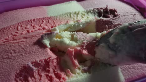 Strawberry,-vanilla-and-black-current-flavored-barbie-theme-striped-ice-cream-in-pink-tub,-delicious-sunday-dessert-being-scooped-with-stainless-steel-spoon