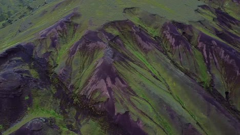 Aerial,-tracking,-drone-shot,-panning-over-green-nature-formations,-in-the-Andes-mountains,-on-a-overcast-day,-near-Cusco,-in-Peru