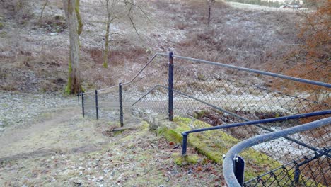 Pan-of-chain-link-fencing-used-at-park,-Winter-time,-Trollhattan,-Sweden