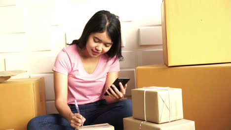 Asiatische-Geschäftsinhaberin,-Die-Zu-Hause-Mit-Verpackungsbox-Am-Arbeitsplatz-Arbeitet