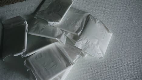 Un-Montón-De-Maxi-Toallas-Sanitarias-Sobre-Una-Superficie-Blanca-Apiladas-Con-Alta-Protección-Menstrual