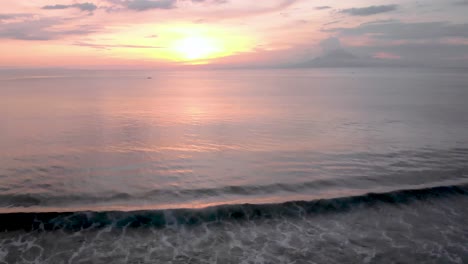 Weitwinkelaufnahme-Aus-Der-Luft-über-Wellen,-Die-Bei-Sonnenuntergang-Auf-Bali-Zusammenbrechen