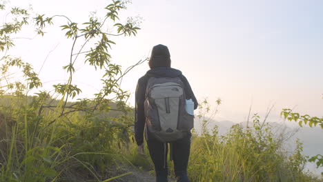 Back-Shot-Of-Young-Woman-Hiking-On-Sunrise