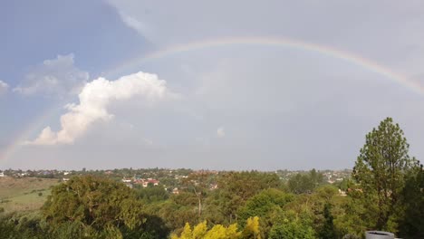 Zeitraffer-Mit-Regenbogen-Nach-Einem-Gewitter,-Während-Sich-Die-Wolken-Entfernen-Und-Die-Sonne-über-Der-Südafrikanischen-Vorstadt-Scheint