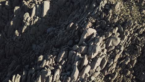 Birdseye-Drone-Aerial-View-on-Rocky-Formations-Under-Evening-Sun
