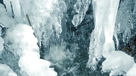 Slow-motion-closeup-of-small-ice-waterfall-caused-by-icy-stream